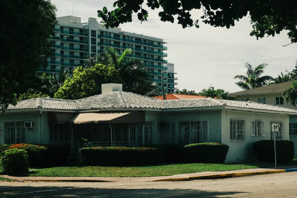 pexels photo 32352498 32352498 Suburban house with lush greenery and a modern high-rise in the background.